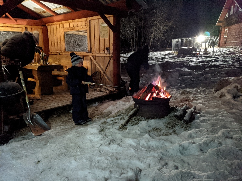 Feu de bois devant un abri du camp, un soir d’hiver