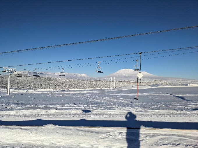 Remontées mécaniques et pistes de ski sous un ciel bleu
